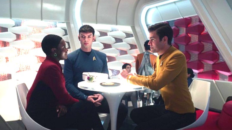 Uhura, Spock, and Kirk sitting