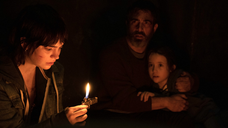 Sadie, Will, and Sawyer sitting huddled around a zippo lighter