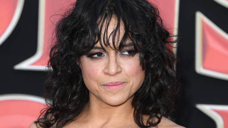 Michelle Rodriguez smirking with curly hair and bangs