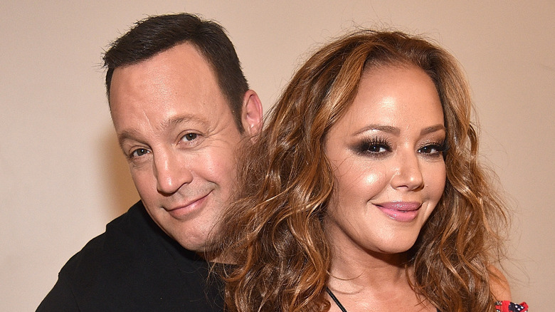 Kevin James standing behind Leah Remini 