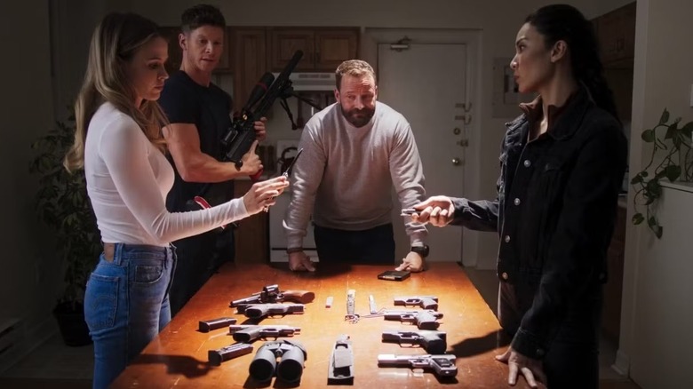 Brandon Beckett's team examining guns on a table