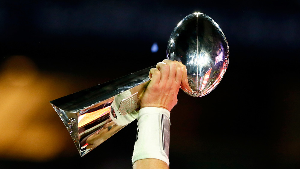 Hand holding Vince Lombardi Trophy