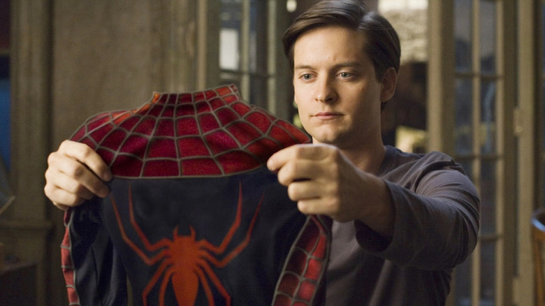 Peter Parker examining Spider-Man suit