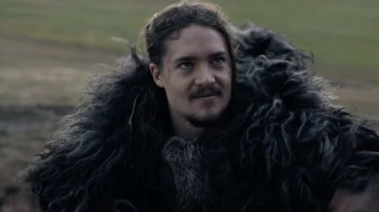 Uhtred smiling while staring up