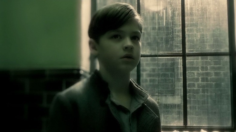 A young Tom Riddle by the window