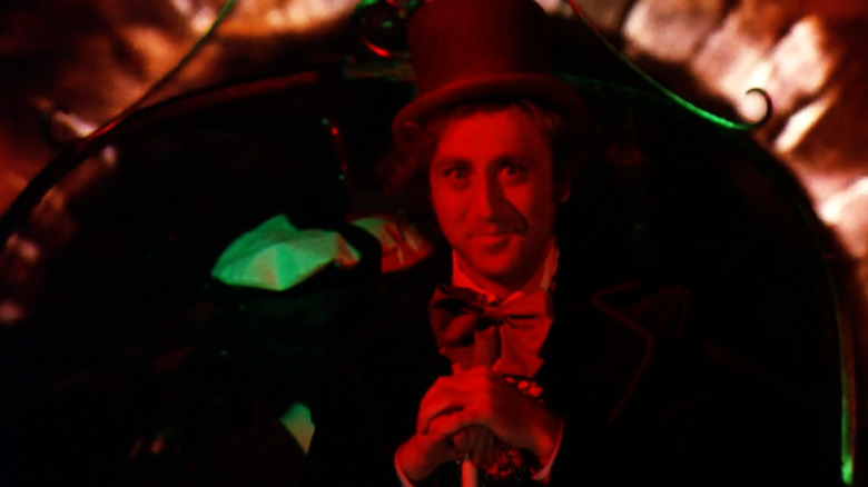 Willy Wonka smiles in a dark tunnel