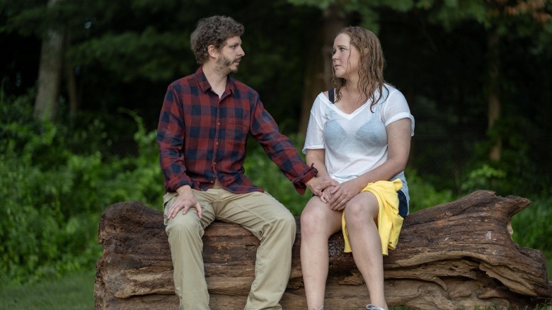 John and Beth sitting together on a log