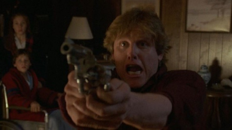 Gary Busey pointing a gun