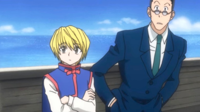 Kurapika standing on a boat looking somber