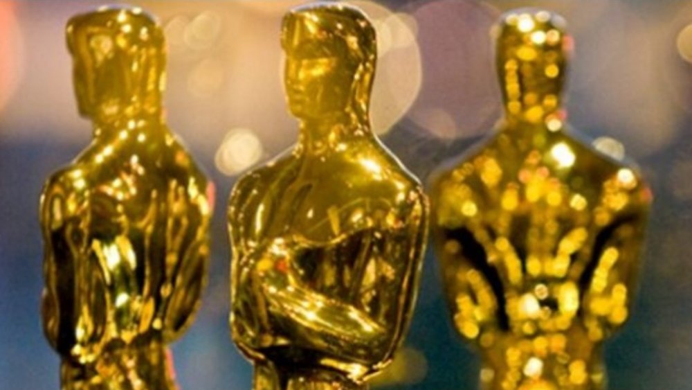 A close-up of gold Oscar statuettes