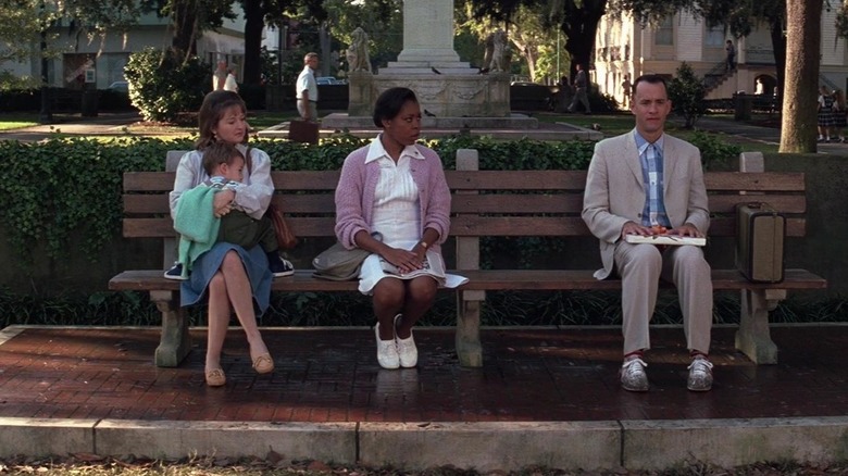 Forrest sitting on bench with two women