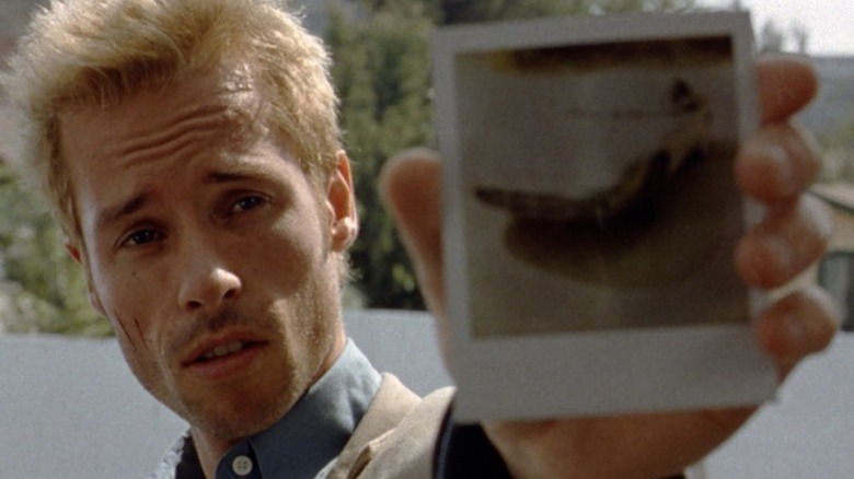 Guy Pearce holding Polaroid