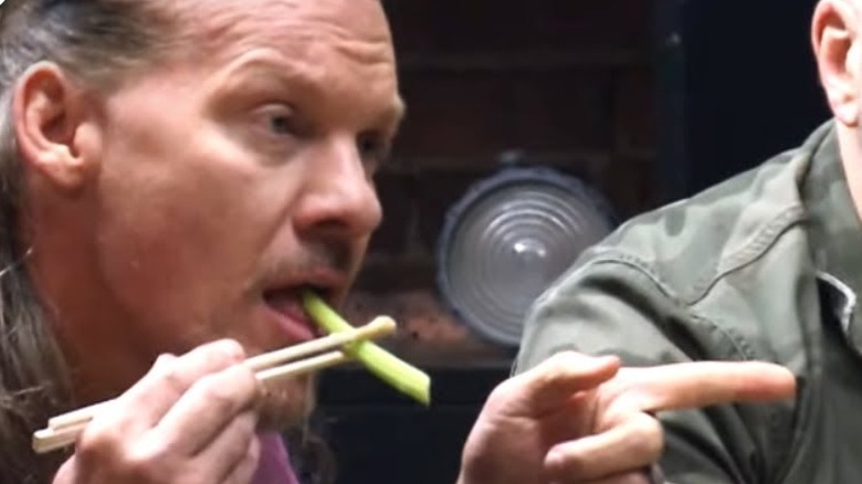 A man eats celery and points