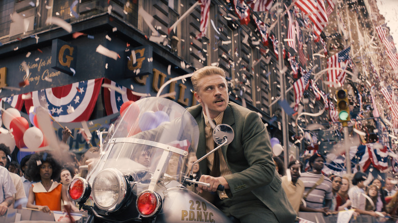 Klaber riding a motorcycle through a parade