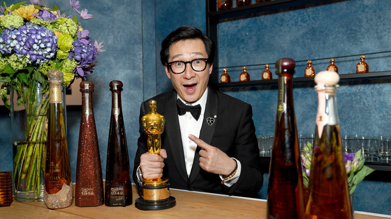 Ke Huy Quan posing with his Oscar