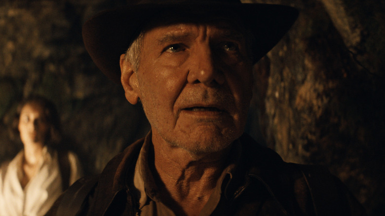 Indiana Jones stands in a cave