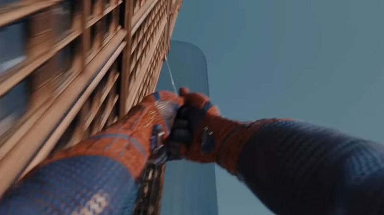 Spider-Man swinging from web off building