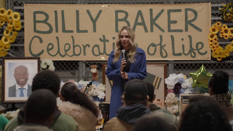 Laura eulogizing Billy Baker in front of sign