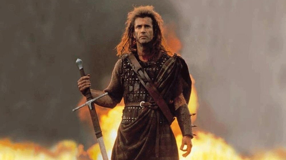 William Wallace with sword on battlefield on fire