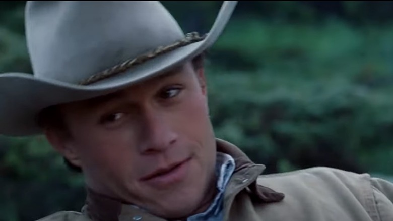 Heath Ledger wears a cowboy hat and smiles in Brokeback Mountain