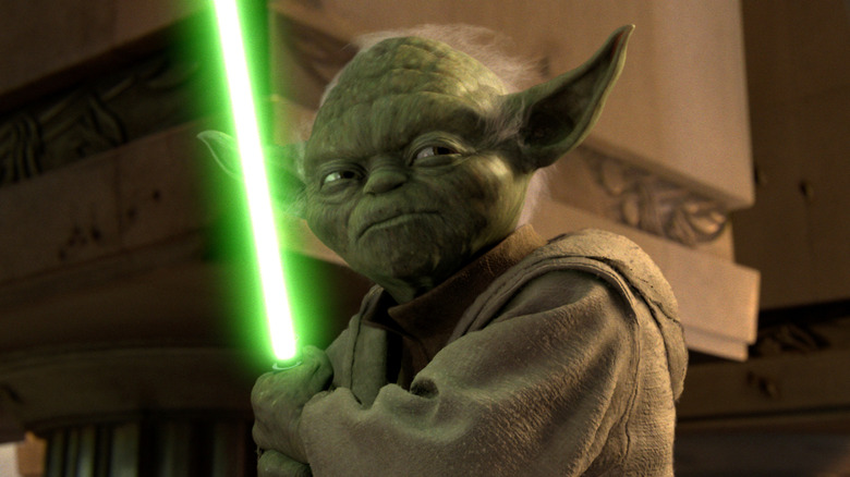 Yoda wielding a lightsaber