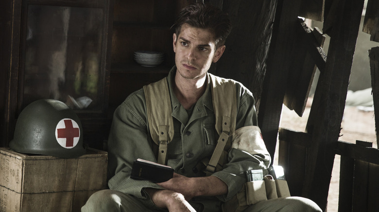 Desmond Doss contemplating while holding a Bible