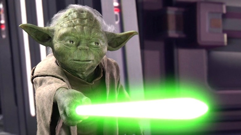 Yoda holds his lightsaber