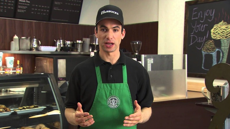 Nathan Fielder wearing a Dumb Starbucks Coffee uniform