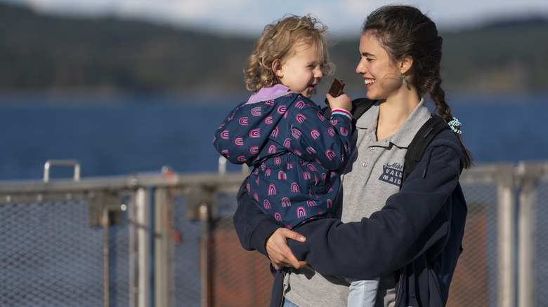 Margaret Qualley holding a child