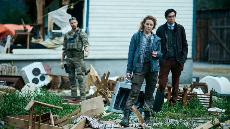 Captain Kris, Nora, and Andreas standing among wreckage