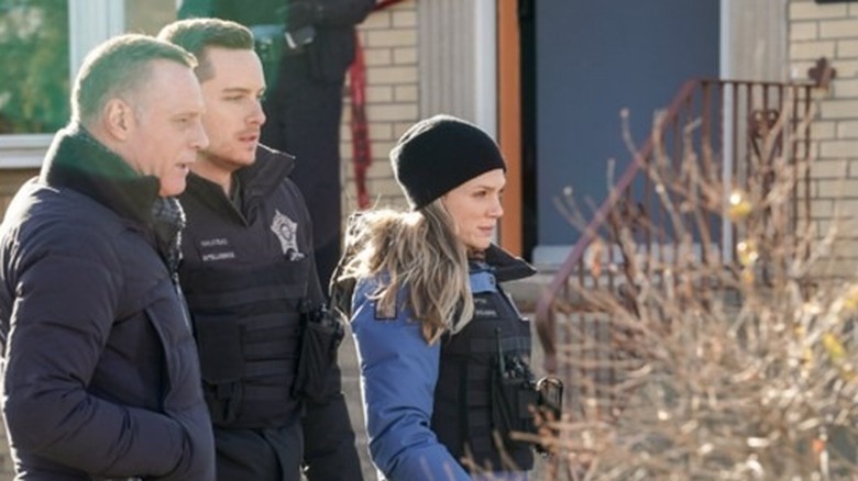 Jason Beghe, Jesse Lee Soffer, Tracy Spiradakos in front of steps