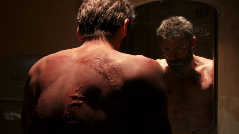 An injured Logan stares at himself in a mirror in "Logan" (2017)