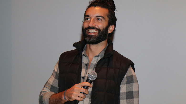 Justin Baldoni holds a microphone