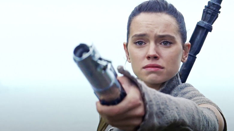 Rey handing lightsaber