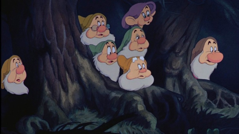 The seven dwarfs look at their lighted cabin