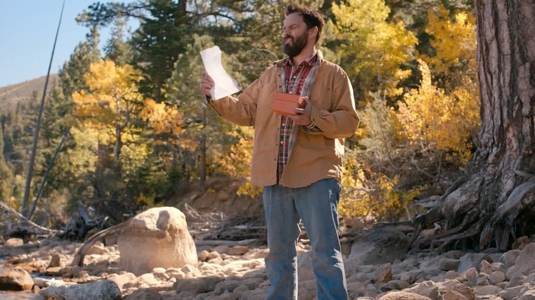 Leif holding Honey's letter in woods