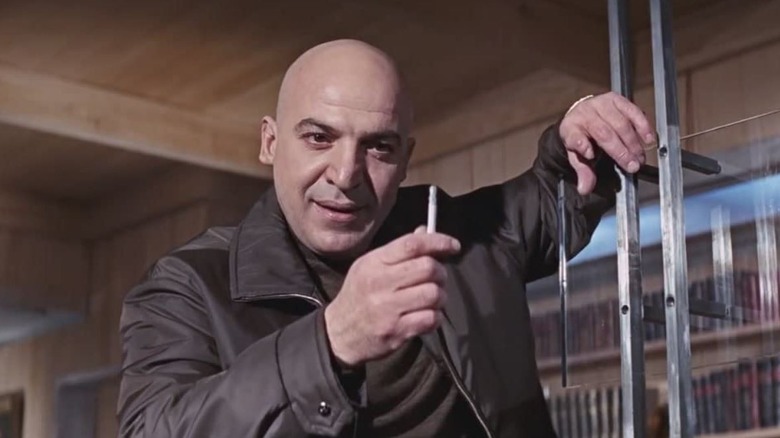 Telly Savalas points with cigarette