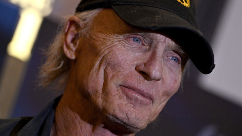 Ed Harris wearing a weathered baseball cap