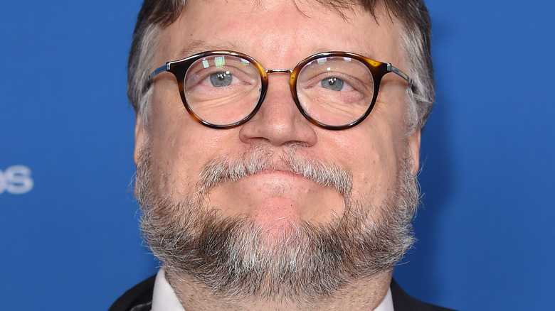 Guillermo del Toro smiling against a blue background