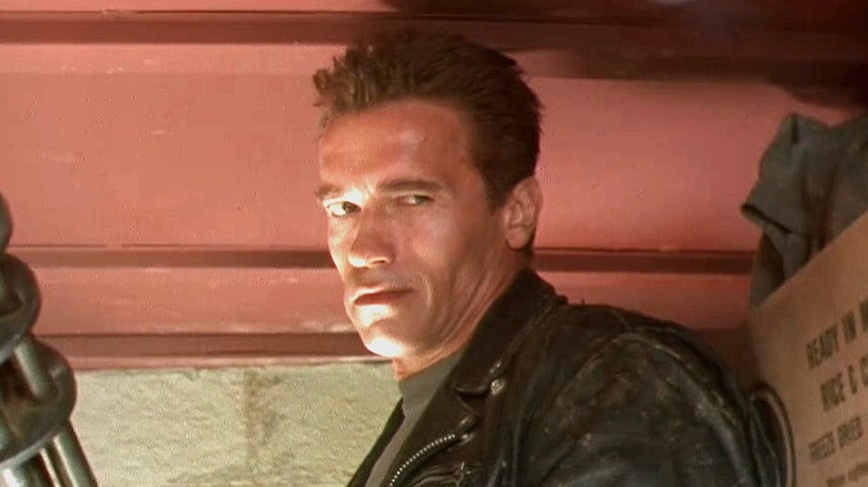 The Terminator stands against a wall