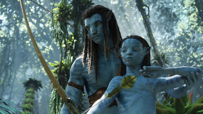Sam Worthington as avatar Jake Sully trying to teach his child how to use bow and arrow