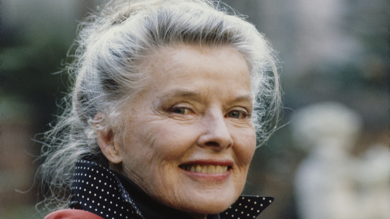 Older Katharine Hepburn smiles over shoulder