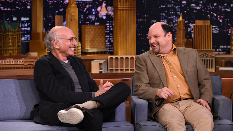 Larry David and Jason Alexander sitting on couch