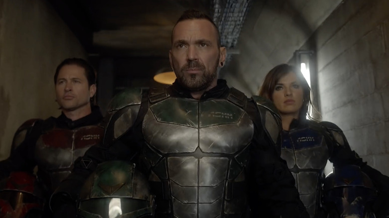 Erik Reed wearing green and silver armor with Iris and Connor