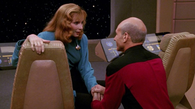 Crusher holds Picard's hand