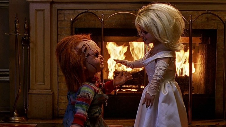 Chucky and Tiff in front of a fireplace in Bride of Chucky