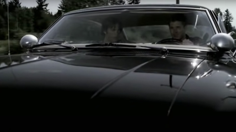 Dean Winchester driving the Impala with Sam in the passenger seat