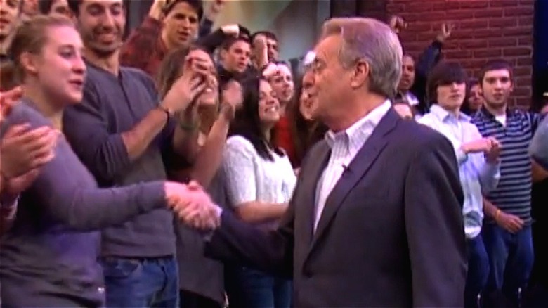 Jerry Springer shakes the hand of an audience member 