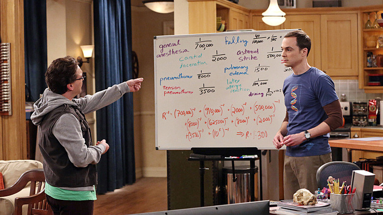 Jim Parsons stands next to a white board