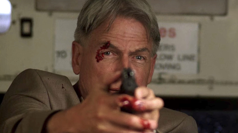 Mark Harmon with blood on eye holding gun